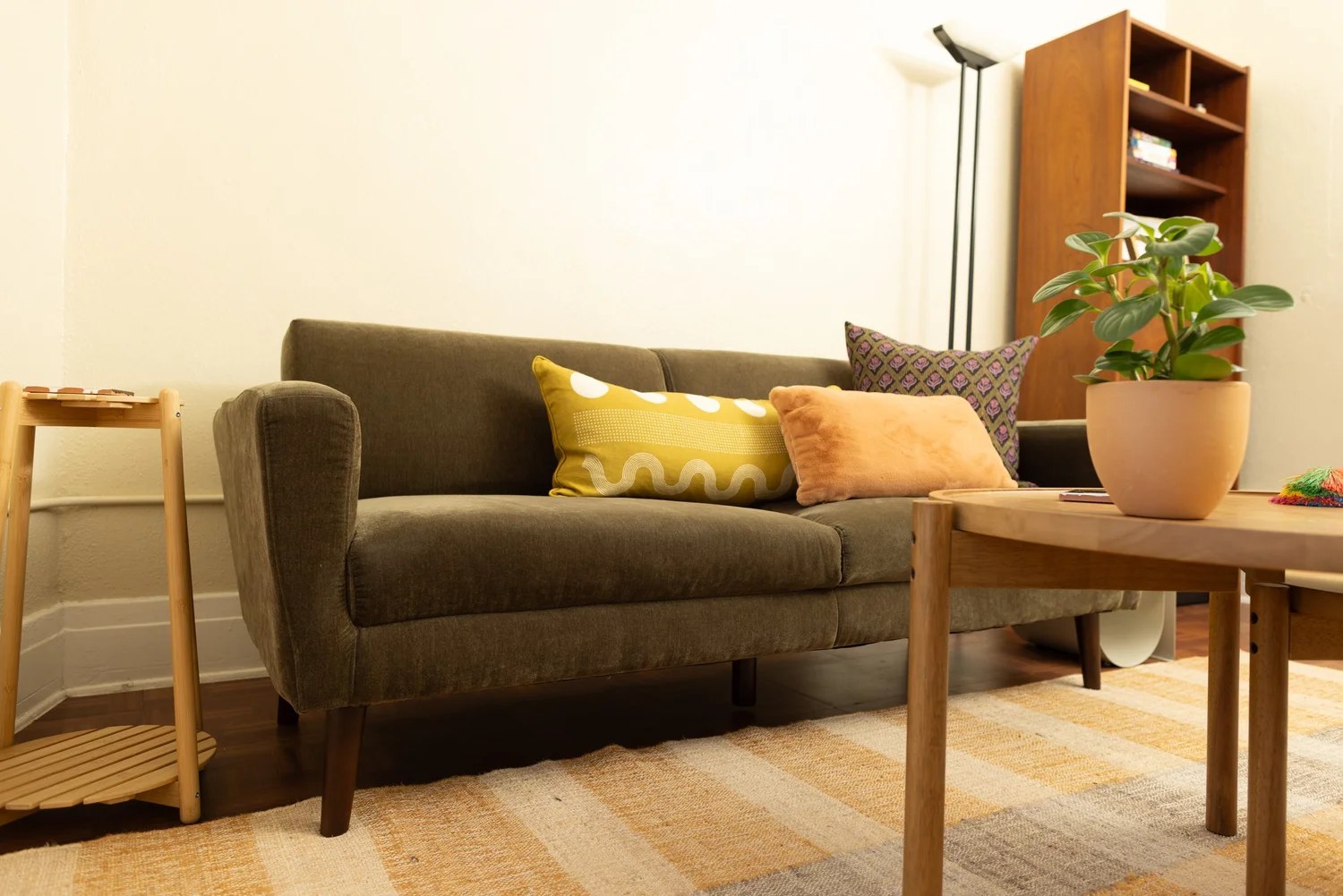 The therapy office in Eagle Rock, Los Angeles: an olive sofa, warm wood, and afternoon light.